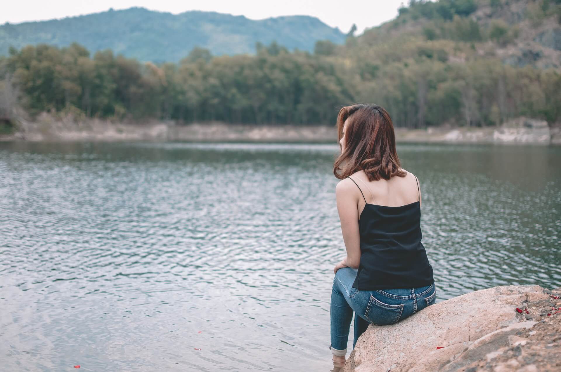 Une femme devant un lac en détente - sophrologie
